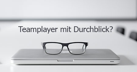 Foto von einer Brille auf einem Laptop mit dem Slogan Teamplayer mit Durchblick